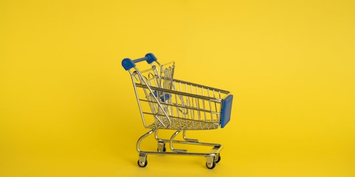 A trolley against a yellow background (representing retail media) A trolley against a yellow background (representing retail media)